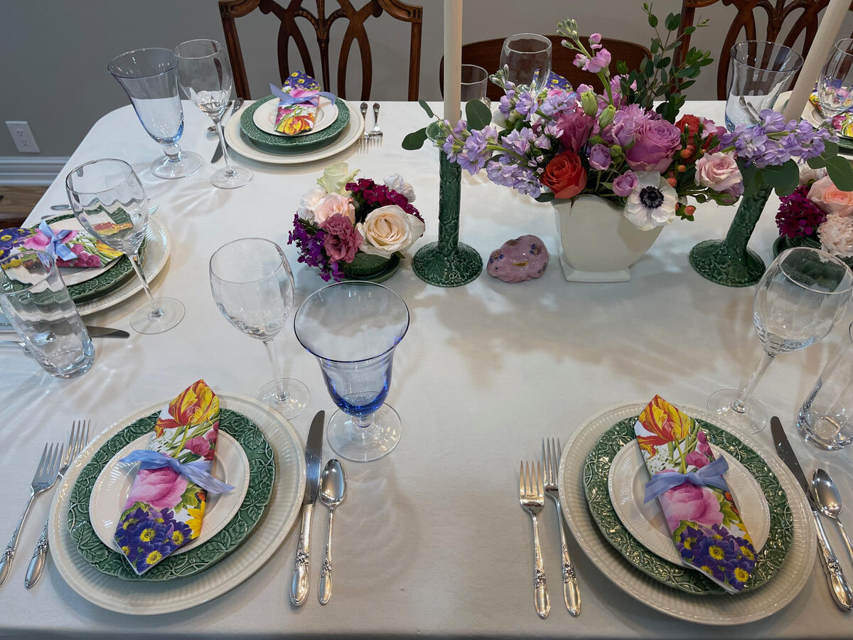 Wedgwood Edme ivory china layered with green cabbage plates and McCoy pottery creates a cheerful Easter gathering.